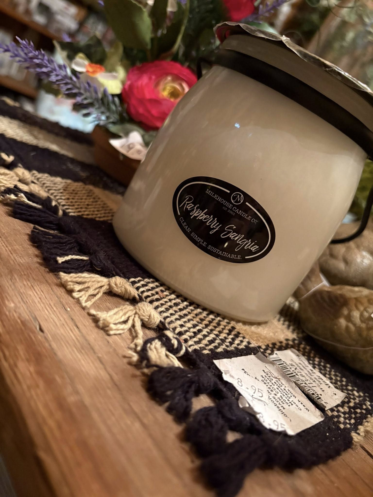 Milkhouse Candle Co. Raspberry Sangria candle on rustic macramé runner