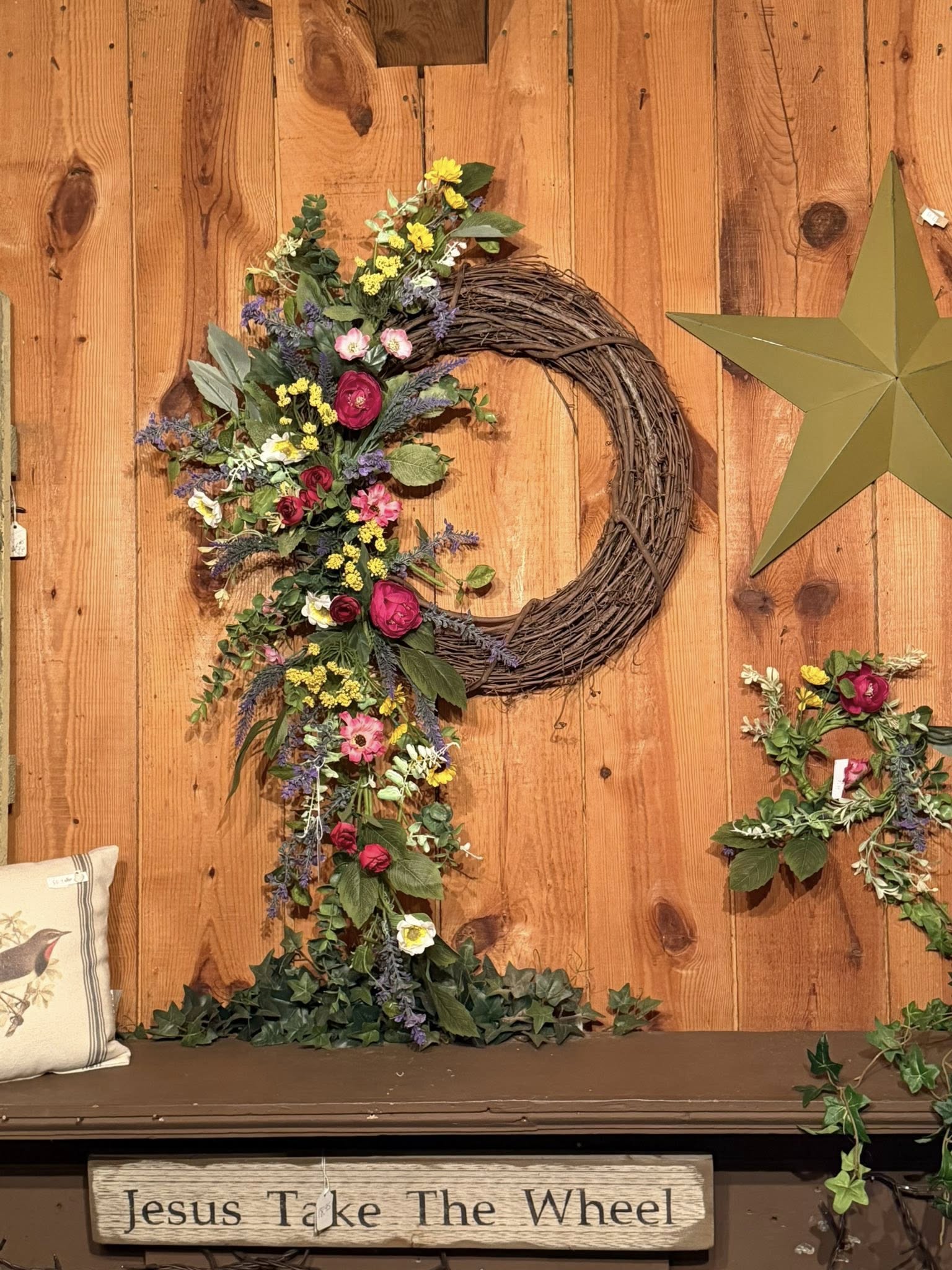 Large handcrafted spring grapevine wreath with colorful wildflowers and trailing ribbons