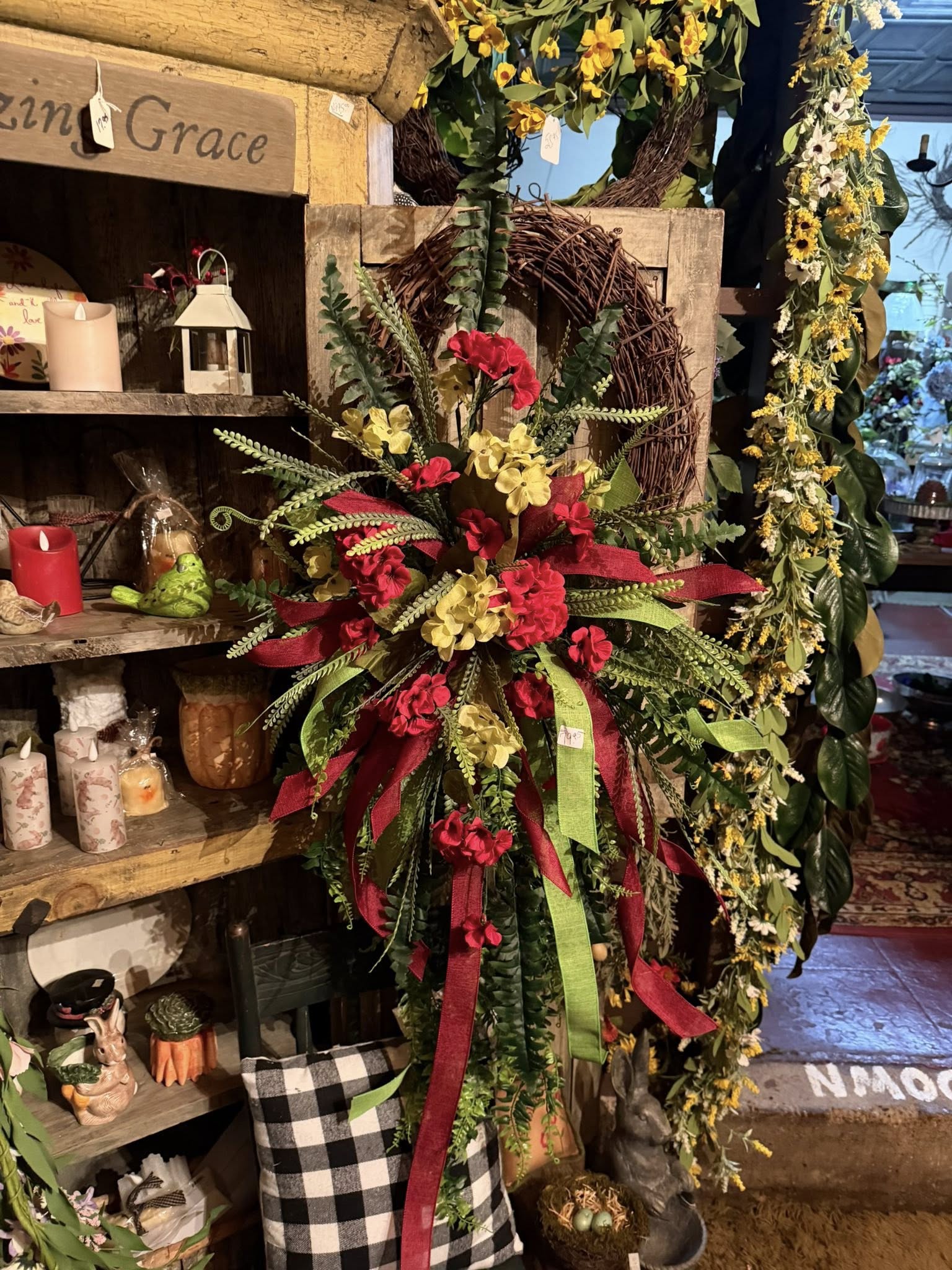 Red and yellow floral wreath displayed inside the store with Amazing Grace sign